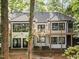 Exterior rear view showcasing large windows, a second story deck, brick accents, and a meticulously maintained lawn at 109 Lochview Dr, Cary, NC 27518