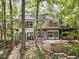 Rear exterior view of home with large windows, deck, brick accents, and a meticulously maintained fenced yard at 109 Lochview Dr, Cary, NC 27518