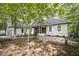 Single-story home featuring a tile roof, a brick front patio, and lush surrounding trees at 109 Lochview Dr, Cary, NC 27518