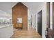 Hallway featuring wood floors, a brick accent wall, and an open view of the living area at 109 Lochview Dr, Cary, NC 27518
