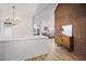 Hallway featuring wood floors, a brick accent wall, and an open view of the kitchen at 109 Lochview Dr, Cary, NC 27518