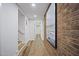 Long hallway with hardwood floors, brick accent wall, and recessed lighting; bright and stylish transition space at 109 Lochview Dr, Cary, NC 27518