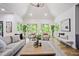 A bright living room featuring vaulted ceilings, a large window with nature view, and comfortable neutral-toned furniture at 109 Lochview Dr, Cary, NC 27518