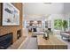 Open-concept living room showcases a brick fireplace, hardwood floors, and seamless connection to a modern kitchen at 109 Lochview Dr, Cary, NC 27518