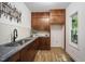 A wet bar with wooden cabinets, a sink, backsplash, and overhead cabinets at 109 Lochview Dr, Cary, NC 27518