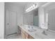 Bright bathroom showcasing a double sink vanity, large mirror, and tiled floor at 1095 Vauxhall Dr, Apex, NC 27502