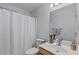 Cozy bathroom featuring a shower with curtain, toilet, and vanity with decorative items at 1095 Vauxhall Dr, Apex, NC 27502