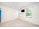 Bright bedroom with two windows, neutral carpet, and a wall-mounted television at 11 Mamie Ferguson Dr, Lillington, NC 27546