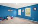 Bedroom with blue walls, neutral carpet, two windows, and decorative artwork on the walls at 11 Mamie Ferguson Dr, Lillington, NC 27546