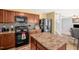Kitchen with an island, dark appliances, and mosaic backsplash at 11 Mamie Ferguson Dr, Lillington, NC 27546
