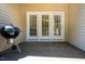A charming back porch features a grill, dark wood, and three white-framed glass panel doors at 111 Florians Dr, Holly Springs, NC 27540
