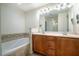 Bright bathroom features a double sink vanity, large mirror, and relaxing soaking tub at 111 Florians Dr, Holly Springs, NC 27540