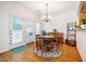 Charming dining area featuring hardwood floors, chandelier, and access to the outdoor patio at 111 Florians Dr, Holly Springs, NC 27540