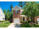 Charming brick two-story home with well-manicured lawn and attached garage under a sunny blue sky at 111 Florians Dr, Holly Springs, NC 27540