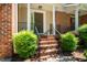 Inviting brick front porch with elegant columns and manicured shrubs enhancing the entryway appeal at 111 Florians Dr, Holly Springs, NC 27540