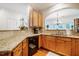 Kitchen featuring wood cabinets, granite counters, tiled backsplash, and black appliances at 111 Florians Dr, Holly Springs, NC 27540