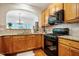 Well-lit kitchen featuring granite counters, tiled backsplash, and black gas range at 111 Florians Dr, Holly Springs, NC 27540