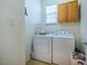 The laundry room features a washer, a dryer, and cabinets at 111 Florians Dr, Holly Springs, NC 27540