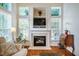 Bright living room with fireplace, built-in shelving, and hardwood floors creating a cozy ambiance at 111 Florians Dr, Holly Springs, NC 27540