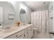 Bathroom with dual sinks, round mirrors, and patterned shower curtain at 112 Parkspring Ct, Cary, NC 27519