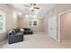 Bright bedroom with a gray couch, ceiling fan, and neutral walls at 112 Parkspring Ct, Cary, NC 27519