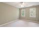 Bright bedroom with neutral walls, two windows, and ceiling fan at 112 Parkspring Ct, Cary, NC 27519