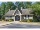 Exterior view of a clubhouse with a gable roof, surrounded by lush landscaping and flowering shrubs at 112 Parkspring Ct, Cary, NC 27519