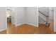 Hallway with hardwood floors provides access to kitchen and stairway at 112 Parkspring Ct, Cary, NC 27519