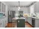 Modern kitchen features stainless steel appliances, stylish white cabinets, and an island at 112 Parkspring Ct, Cary, NC 27519