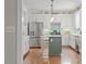 Bright kitchen features stainless steel appliances, stylish white cabinets, and an island at 112 Parkspring Ct, Cary, NC 27519