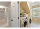 Functional laundry room with washer, dryer, shelf, and natural light at 112 Parkspring Ct, Cary, NC 27519