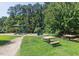 Community playground with swings, slides, picnic tables, and a walking path in a park-like setting at 112 Parkspring Ct, Cary, NC 27519
