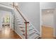Elegant staircase with hardwood steps and a white banister, connecting the home's multiple floors at 112 Parkspring Ct, Cary, NC 27519