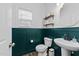 Stylish powder room with dark green wainscoting, decorative mirror, and modern fixtures at 116 Chaseford Ct, Holly Springs, NC 27540