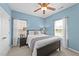 Relaxing bedroom with blue walls, a ceiling fan, and bright windows for a peaceful retreat at 116 Chaseford Ct, Holly Springs, NC 27540