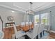 Open-concept dining room featuring wood flooring, chandelier, and light blue walls at 116 Chaseford Ct, Holly Springs, NC 27540