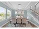 Elegant dining room with large windows, coffered ceilings, chandelier, and seating for six at 116 Chaseford Ct, Holly Springs, NC 27540