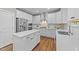 Beautiful white kitchen with stainless steel appliances, large center island, and wood flooring at 116 Chaseford Ct, Holly Springs, NC 27540