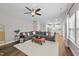 Open-concept living room with a gray sofa, ottoman, and a view of the kitchen at 116 Chaseford Ct, Holly Springs, NC 27540