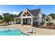 View of the pool house next to community pool, showcasing a modern design with ample seating and amenities at 116 Chaseford Ct, Holly Springs, NC 27540