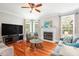 Cozy living room with a fireplace, hardwood flooring, large windows, and comfortable seating arrangements at 116 Dallavia Ct, Morrisville, NC 27560