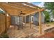 Beautifully designed patio with wooden pergola, ceiling fans, and a stone-accented sitting wall for relaxation at 116 Dallavia Ct, Morrisville, NC 27560