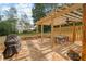 Inviting backyard patio with wooden pergola, ceiling fan, and stone accents, ideal for outdoor gatherings at 116 Dallavia Ct, Morrisville, NC 27560