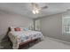 Bright bedroom features a ceiling fan, two windows, and a bed with stylish coral-themed bedding at 120 Foley Dr, Garner, NC 27529