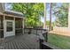 View of the wooden deck with gray railing and a screened-in porch, surrounded by trees in the backyard at 120 Foley Dr, Garner, NC 27529