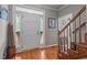 Bright foyer with a white front door, hardwood floors, staircase with wood railing, and decorative accents at 120 Foley Dr, Garner, NC 27529