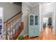 Hallway featuring hardwood floors, staircase with wood railing, and a decorative cabinet at 120 Foley Dr, Garner, NC 27529