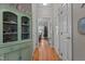 Hallway featuring hardwood floors, decorative cabinet, and view into dining room with Christmas tree at 120 Foley Dr, Garner, NC 27529