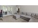 Spacious living room featuring a comfortable sectional sofa and view to the outdoor patio through glass doors at 120 Foley Dr, Garner, NC 27529