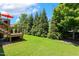 Spacious backyard with green grass, privacy trees and partial view of deck at 120 Mearleaf Pl, Holly Springs, NC 27540